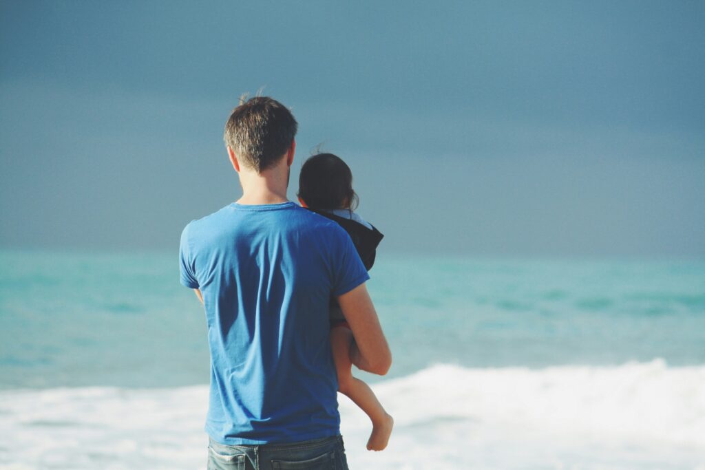 A father and child watching the waves together